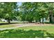 Community park featuring benches, walking path, book boxes, lawn, and swimming pool beyond the trees at 3421 E Jameson Rd, Raleigh, NC 27604