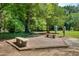 Outdoor park space with brick patio, stone benches, book boxes, and surrounding greenery at 3421 E Jameson Rd, Raleigh, NC 27604