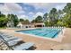 View of community pool, lounge chairs and pool house amidst mature trees and green space at 3421 E Jameson Rd, Raleigh, NC 27604