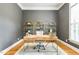 Well-lit home office featuring modern desk, decorative shelving, and hardwood floors at 3530 Thorndike Dr, Wake Forest, NC 27587