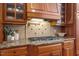Close up on gourmet kitchen with gas cooktop and custom tile backsplash at 3530 Thorndike Dr, Wake Forest, NC 27587