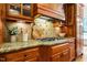 Close up on gourmet kitchen with gas cooktop and custom tile backsplash at 3530 Thorndike Dr, Wake Forest, NC 27587