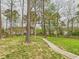 Expansive backyard with lush greenery, mature trees, and a wooden walkway for tranquil strolls at 3705 Andoversford Ct, Wake Forest, NC 27587