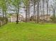 Lush backyard with mature trees, a green lawn, and an inviting outdoor space at 3705 Andoversford Ct, Wake Forest, NC 27587