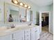 Bright bathroom featuring double sinks, white cabinets, and updated fixtures and mirrors at 3705 Andoversford Ct, Wake Forest, NC 27587