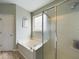 Clean bathroom showcases a jetted tub, glass shower, and window for light, combining comfort and functionality at 3705 Andoversford Ct, Wake Forest, NC 27587