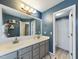 Bathroom with a large mirror over a double sink vanity, complemented by stylish light fixtures at 3705 Andoversford Ct, Wake Forest, NC 27587