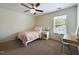 Comfortable bedroom features a ceiling fan, a twin bed, a vanity, and natural light at 3705 Andoversford Ct, Wake Forest, NC 27587