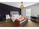 Charming bedroom featuring a modern accent wall, stylish light fixture, and comfortable furnishings at 3705 Andoversford Ct, Wake Forest, NC 27587