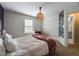 Bright bedroom featuring a cozy bed, stylish light fixture, and natural light from the window at 3705 Andoversford Ct, Wake Forest, NC 27587