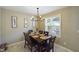 Charming dining area with a wooden table, chandelier, and large window, with a serene view of the outdoors at 3705 Andoversford Ct, Wake Forest, NC 27587
