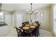 Cozy dining area featuring a dark wood table, chandelier, and decorative wall art, illuminated by natural light at 3705 Andoversford Ct, Wake Forest, NC 27587