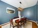 Dining room featuring stylish light fixture, seating for six, and blue accent wall at 3705 Andoversford Ct, Wake Forest, NC 27587