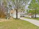 View of the 2-car garage and driveway of this lovely home and a brick house next to it at 3705 Andoversford Ct, Wake Forest, NC 27587