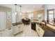 Bright kitchen featuring tile floors, an island, stainless steel sink, and an adjacent dining area for modern living at 3705 Andoversford Ct, Wake Forest, NC 27587