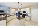 Modern kitchen with white cabinets, dark countertops, and an island, adjacent to a dining area at 3705 Andoversford Ct, Wake Forest, NC 27587