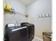 Well-organized laundry room with modern washer, dryer, shelving, and practical hooks for efficient home management at 3705 Andoversford Ct, Wake Forest, NC 27587