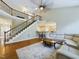 Spacious living room featuring a staircase, hardwood floors, and neutral decor with a comfortable white sectional sofa at 3705 Andoversford Ct, Wake Forest, NC 27587