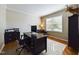 Well-lit home office with large desk, chair, and traditional leather sitting chair at 3705 Andoversford Ct, Wake Forest, NC 27587
