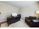 A home office features a dark desk, chair, brown leather seat, and light colored walls at 3705 Andoversford Ct, Wake Forest, NC 27587