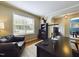 Well-lit home office with large window, dark desk and leather chair in view at 3705 Andoversford Ct, Wake Forest, NC 27587