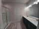Modern bathroom featuring a double sink vanity, wide mirror, and tiled shower at 384 Hopewell Branch Ct, Smithfield, NC 27577