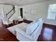 Bright living room featuring hardwood floors, a white couch, and a staircase at 3908 Bostwyck Dr, Fuquay Varina, NC 27526