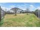 Spacious backyard, features a view of the home, a screen porch, and a wooden fence at 401 Club Center Dr, Youngsville, NC 27596