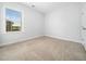 Bright bedroom features neutral carpet and paint and a window letting in natural light at 401 Club Center Dr, Youngsville, NC 27596