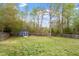 Spacious backyard featuring a shed, mature trees, and a well-maintained lawn at 408 Teal Lake Dr, Holly Springs, NC 27540