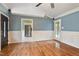 Open-concept living room boasts hardwood floors, wainscoting, and access to the kitchen and back porch at 408 Teal Lake Dr, Holly Springs, NC 27540
