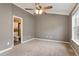 Cozy bedroom featuring carpet, ceiling fan, and ensuite bathroom access at 408 Teal Lake Dr, Holly Springs, NC 27540