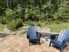 Beautiful outdoor space with bluestone patio, chairs and a lovely wooded view perfect for entertaining at 420 Cahors Trl, Holly Springs, NC 27540