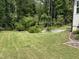 Expansive backyard featuring well-maintained lawn and lush greenery, perfect for outdoor activities at 420 Cahors Trl, Holly Springs, NC 27540