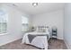 Cozy bedroom featuring large bright window and plush neutral carpet flooring at 420 Cahors Trl, Holly Springs, NC 27540