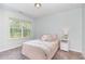 Inviting bedroom with neutral decor, plush carpet and large bright window at 420 Cahors Trl, Holly Springs, NC 27540