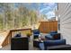 This cozy deck has dark wicker furniture with plush blue cushions and a wooded view at 420 Cahors Trl, Holly Springs, NC 27540
