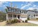 Charming two-story home with a landscaped yard, inviting front porch, and a two-car garage at 420 Cahors Trl, Holly Springs, NC 27540