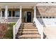 Inviting front entrance with brick steps, white railings, and a decorative wreath on the front door at 420 Cahors Trl, Holly Springs, NC 27540