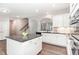 Bright kitchen features white cabinets, granite countertops, an island and stainless steel appliances at 420 Cahors Trl, Holly Springs, NC 27540