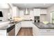 Bright kitchen featuring white cabinets, granite countertops, stainless steel appliances, and a kitchen island at 420 Cahors Trl, Holly Springs, NC 27540