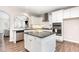 Bright kitchen with white cabinetry, granite countertops, stainless steel appliances, and kitchen island at 420 Cahors Trl, Holly Springs, NC 27540