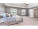 Spacious main bedroom featuring large bright window and neutral carpet flooring at 420 Cahors Trl, Holly Springs, NC 27540