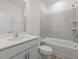 This bathroom has a white vanity with a tub shower combo with gray tile at 426 Adams Pointe Ct, Angier, NC 27501