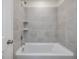 Bathroom shower and bath combo featuring gray tiling and a chrome showerhead at 426 Adams Pointe Ct, Angier, NC 27501