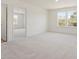 Large bedroom with carpeting, two windows, and a doorway leading to another room providing privacy at 426 Adams Pointe Ct, Angier, NC 27501