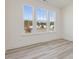 Sunlit bedroom has three large windows and wood-look flooring, offering a serene space at 426 Adams Pointe Ct, Angier, NC 27501