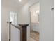 Upstairs hallway with hardwood railing leading to the bathroom featuring white vanities at 426 Adams Pointe Ct, Angier, NC 27501