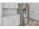 Close-up of a kitchen with stainless steel refrigerator, white cabinets, and marble countertops at 426 Adams Pointe Ct, Angier, NC 27501