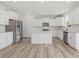 Modern white kitchen featuring an island, stainless steel appliances, and ample cabinet space at 426 Adams Pointe Ct, Angier, NC 27501
